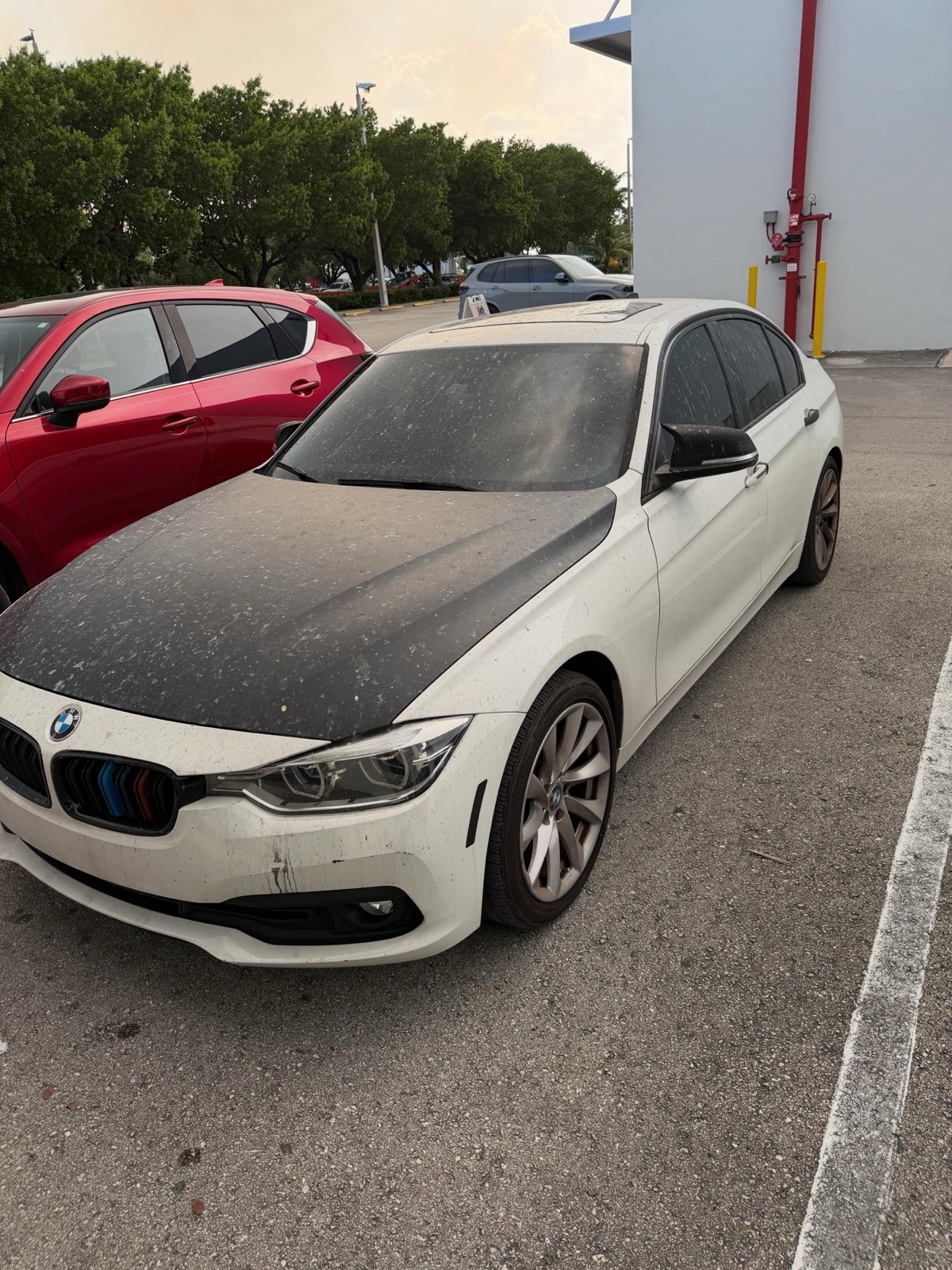 A BMW covered in ash before detailing