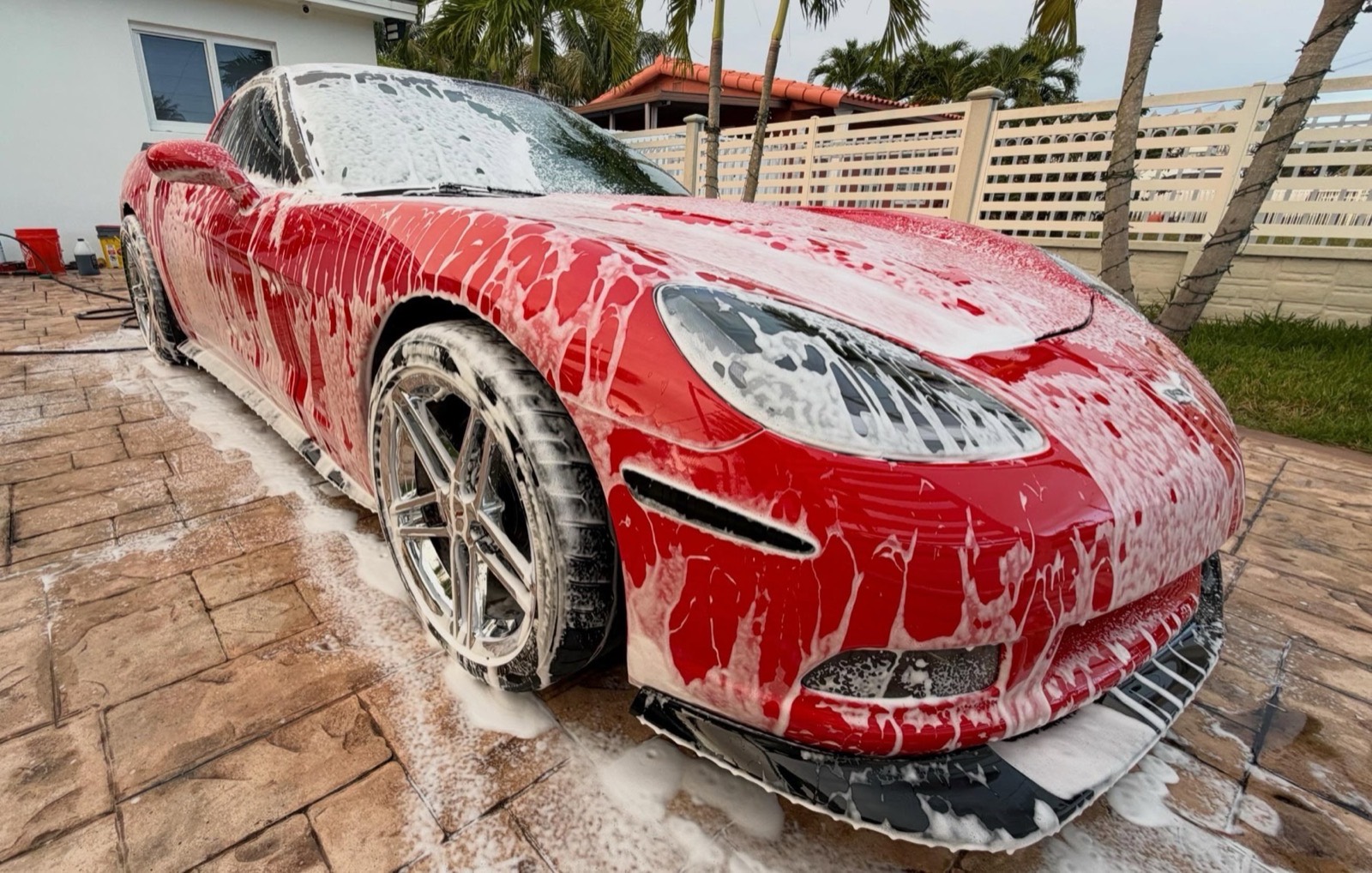 Thick foam covering the front of a car during an exterior wash