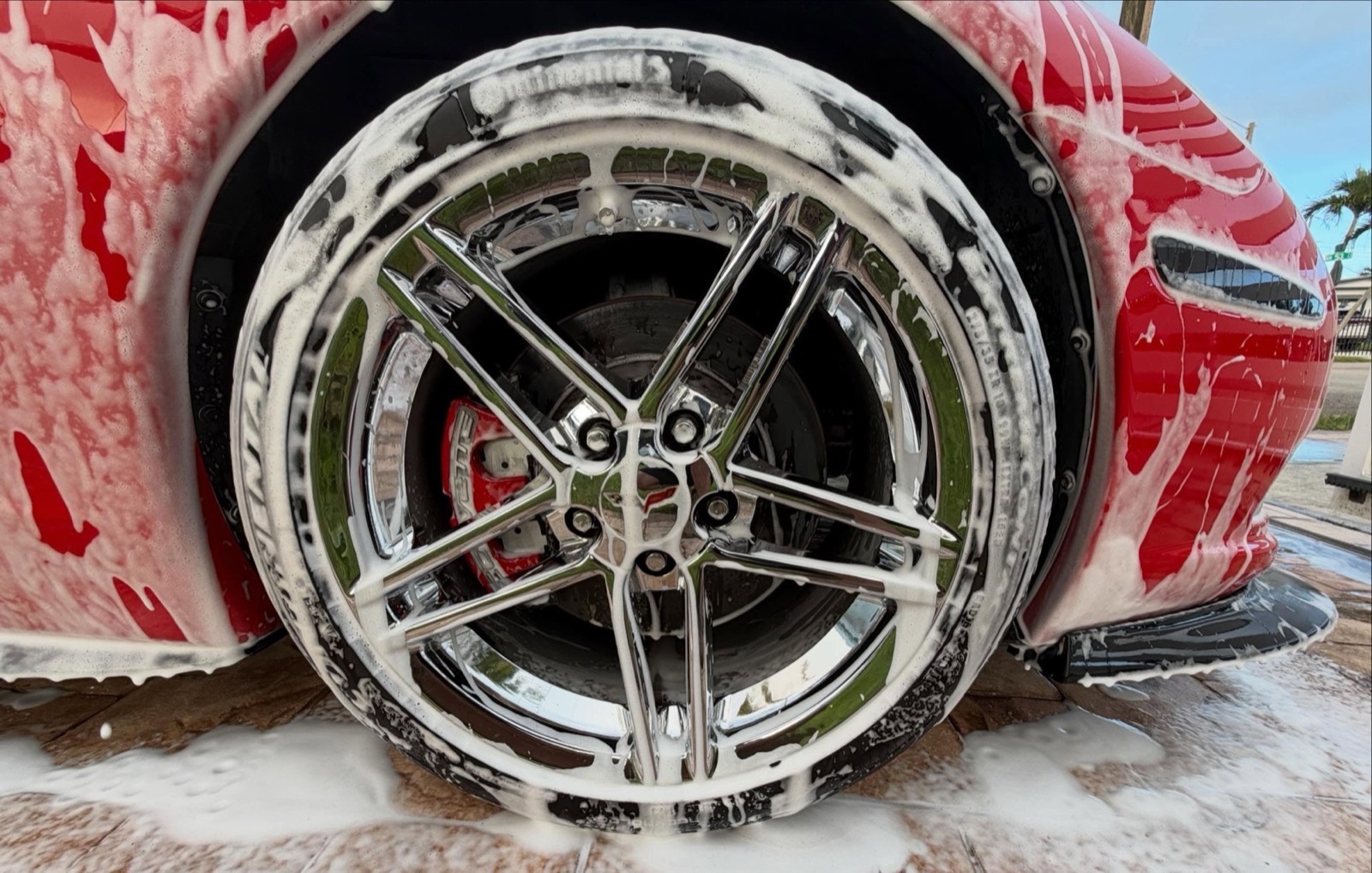 Foam suds along the side of a car during a wash